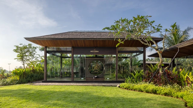 The glass hot yoga pavilion at Eden, opening onto tropical gardens